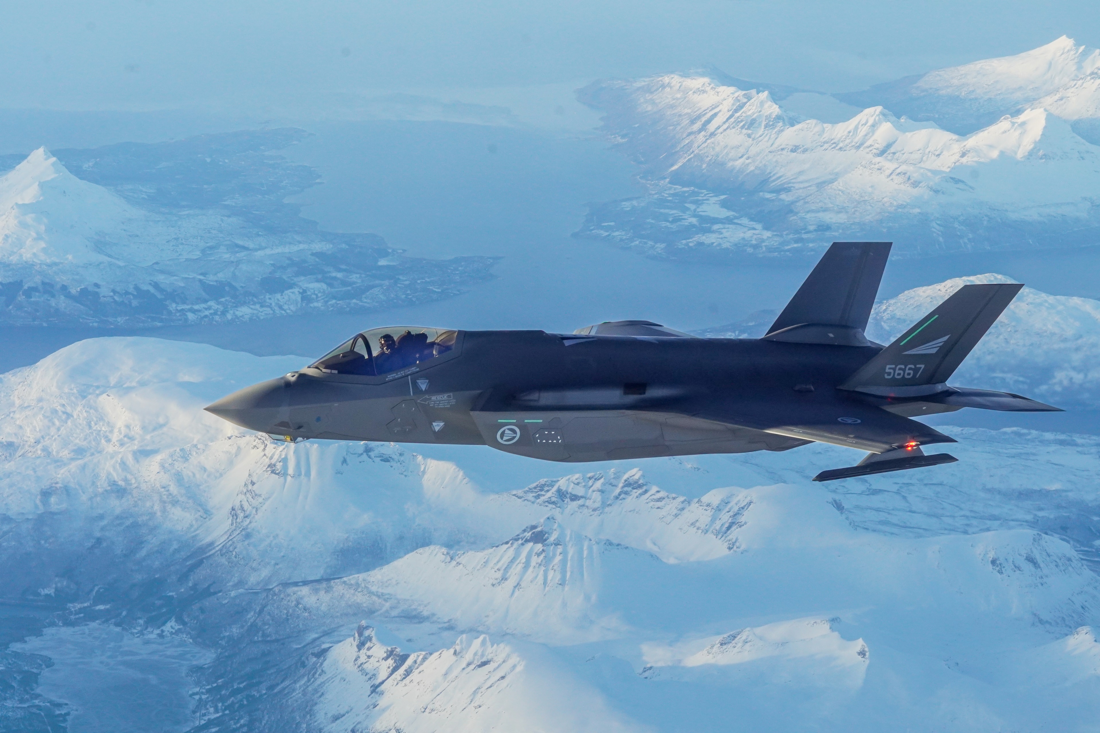 Jagerfly over snødekt fjellandskap.